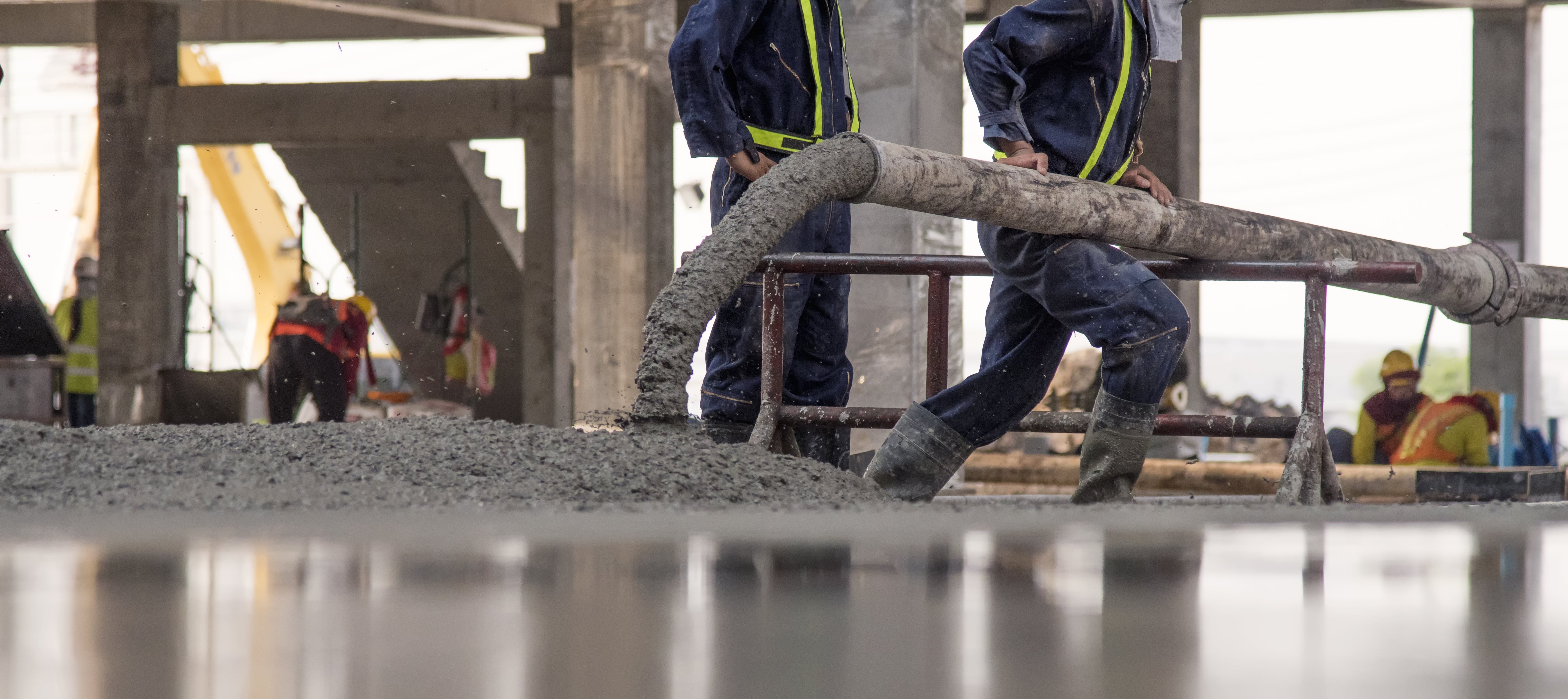 construction worker concrete pouring during commercial concreting min